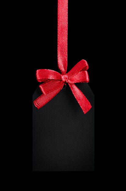 Black tag with red bow on black isolated background