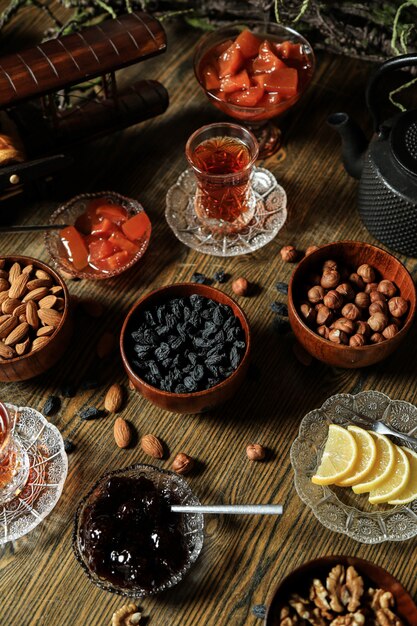 Black tea in armudu glass with various nuts and jam