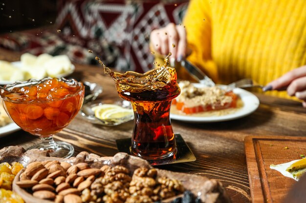 Black tea in armudu glass with various sweets on the table close up view