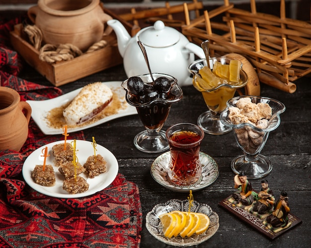 Black tea in armudu glass with various sweets