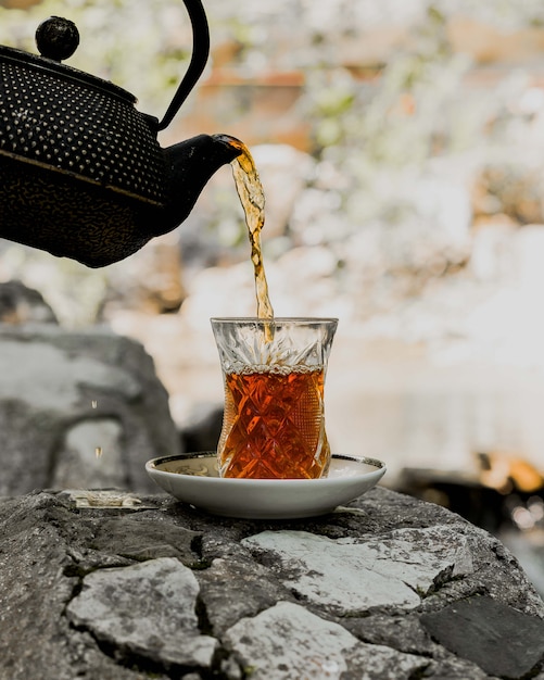 Free photo black tea served in traditional armudu glass