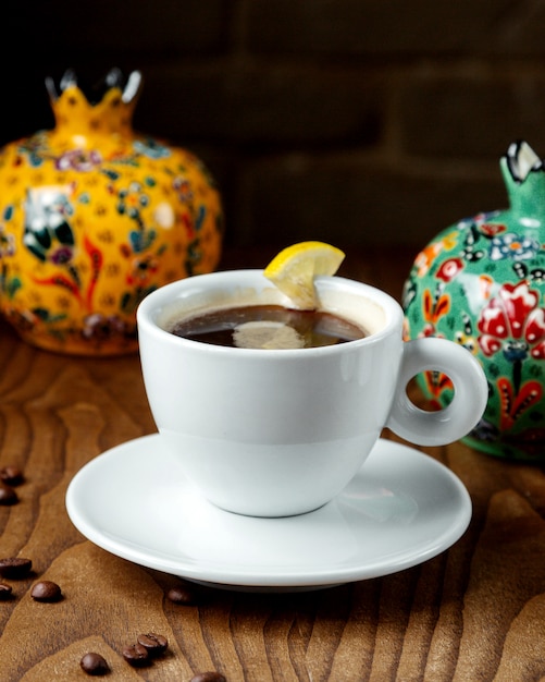 Foto gratuita tè nero al limone in una tazza