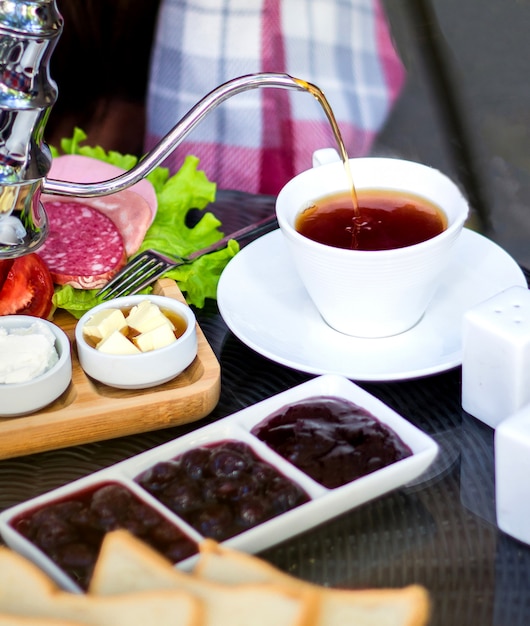 Foto gratuita tè nero con marmellata e salsicce varie