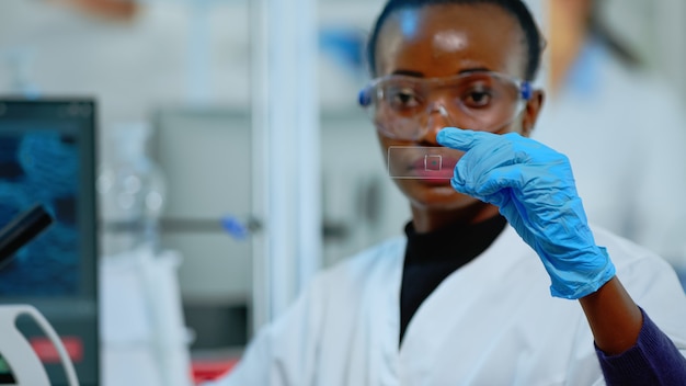 結果​を​見ている​近代的​な​設備​の​整った​実験室​で​実験​を​している​黒人​の​技術者​。​さまざまな​細菌​組織​や​血液​サンプル​を​扱う​アフリカ​の​科学者​、​抗生​物質​の​製薬​研究​の​概念