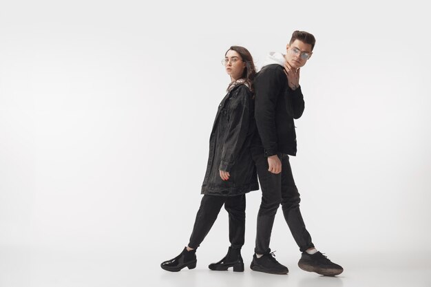 In black. Trendy fashionable couple isolated on white studio wall.