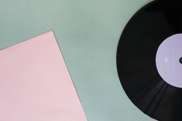 Black vinyl record with paper on table