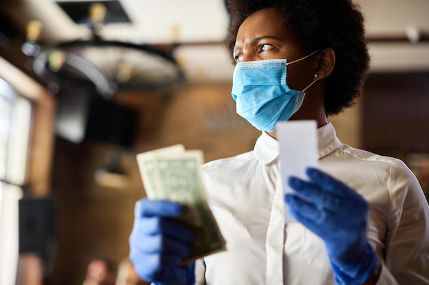 Black waitress feeling displeased about the tip from a customer