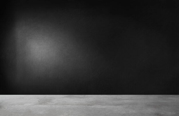 Black wall in an empty room with concrete floor