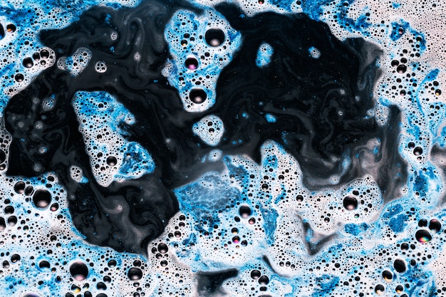 Free photo black water with mixing blue and white paint