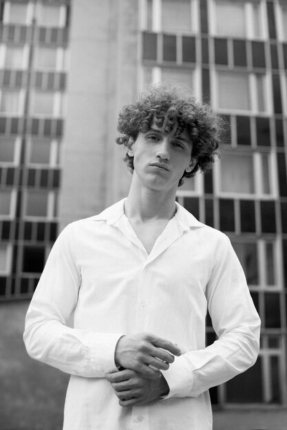 Black and white analog portrait of handsome man posing artistically outdoors