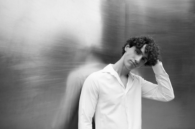 Free photo black and white analog portrait of handsome man posing artistically outdoors