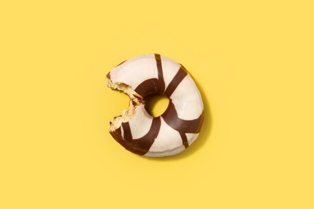 Black and white chocolate donut on yellow background