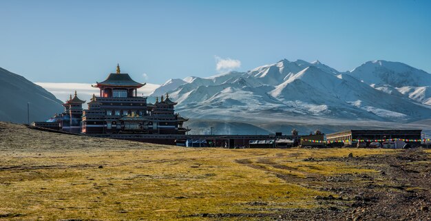 青い空の下の山の近くの黒と白の家