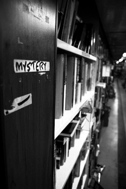 Premium Photo Black And White Perspective Depth Shot Of A Row Of Books In The Mystery Section Of A Library Or Book