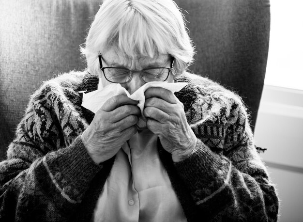 高齢者の女性のくしゃみの白黒写真