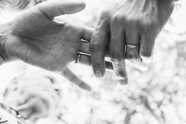 Black and white picture of newlyweds' hands holding each other tender