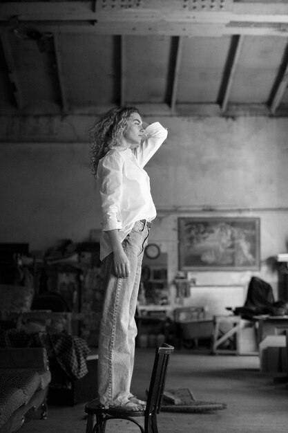 Black and white portrait of beautiful woman posing indoors on a chair