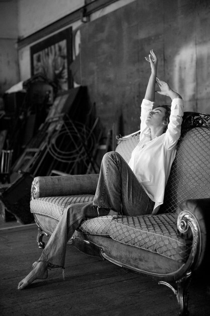 Black and white portrait of beautiful woman posing indoors on a couch