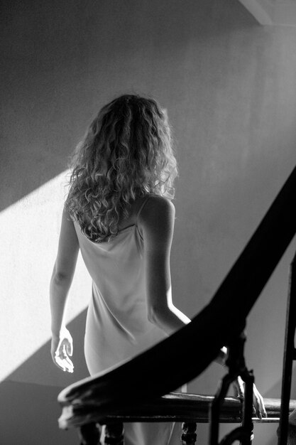 Black and white portrait of beautiful woman posing indoors in a dress