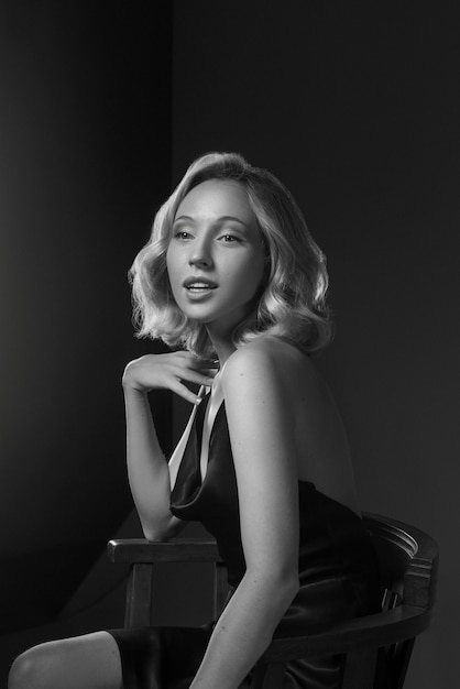 Black and white portrait of woman on chair in old hollywood glamour style