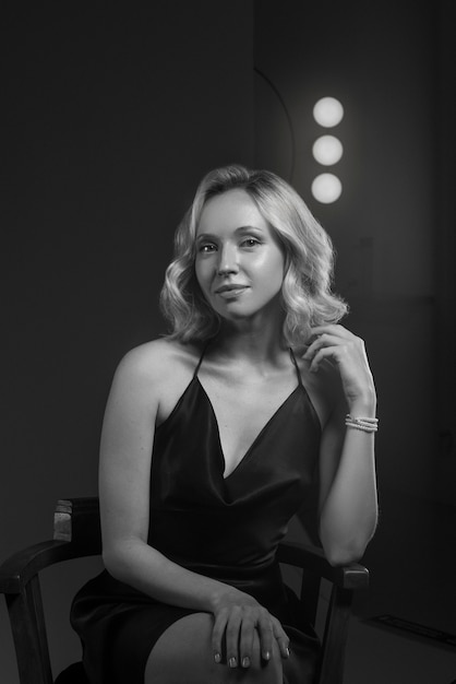 Free photo black and white portrait of woman on chair in old hollywood glamour style