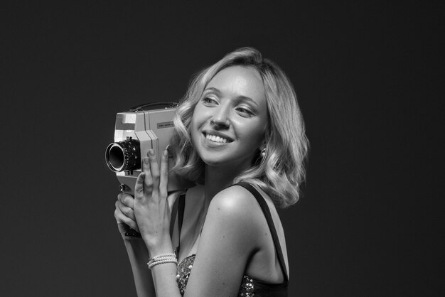 Black and white portrait of woman with camera in old hollywood glamour style