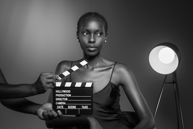 Black and white portrait of woman with clapperboard in old hollywood glamour style