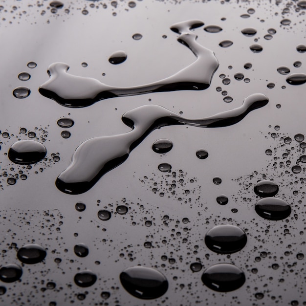 Free photo black-and-white shot of liquid drops on a surface