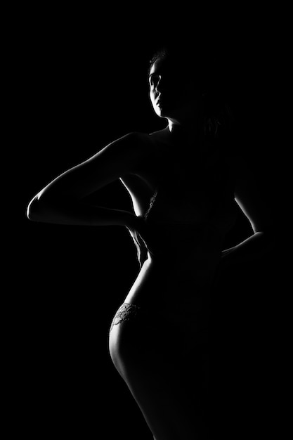 Black and white silhouette of young, sporty and sexy woman in lingerie