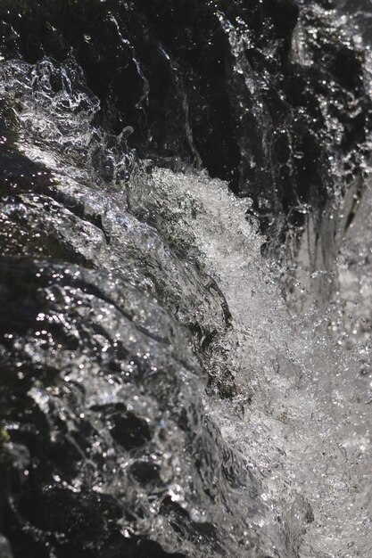 Черно-белый вертикальный снимок брызг струи воды