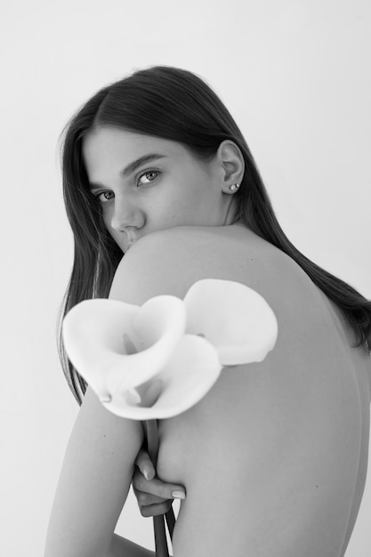 Free photo black and white woman posing with flower side view