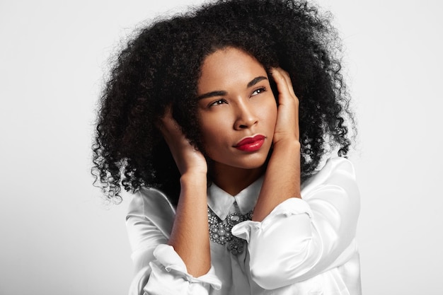 Foto gratuita la donna di colore si chiuse l'orecchio per i capelli afro che guardavano da parte