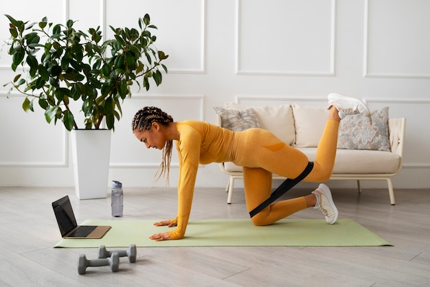 Free photo black woman doing fitness at home