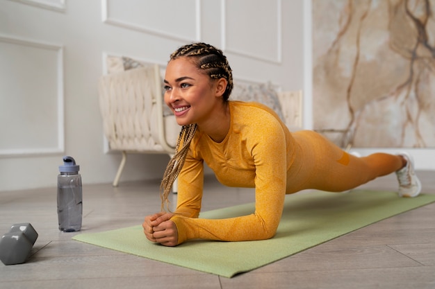 Foto gratuita donna di colore che fa forma fisica a casa