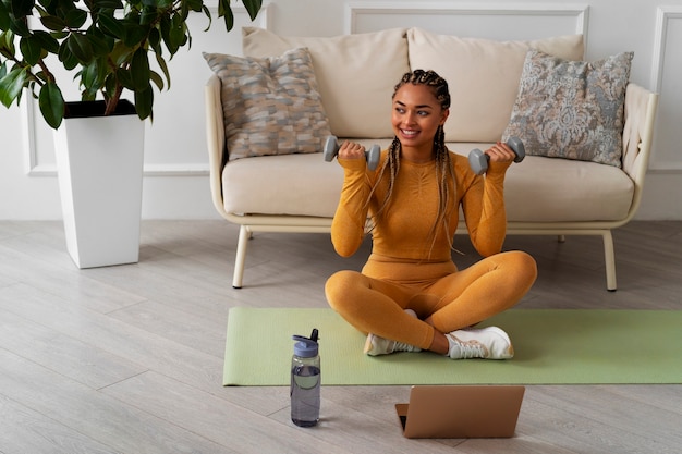 Free photo black woman doing fitness at home