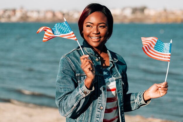 Black woman holding American flags in hands