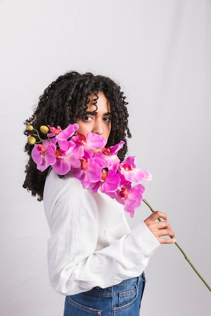 Free photo black woman holding pink flower