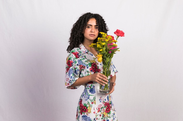 Free photo black woman holding vase with flowers