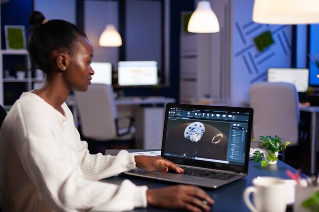 Black woman in mechanical industry working late at night doing overtime in start-up office