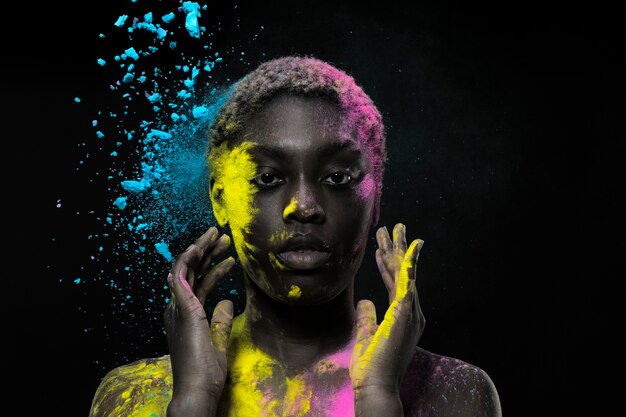 Black woman posing with colorful powder