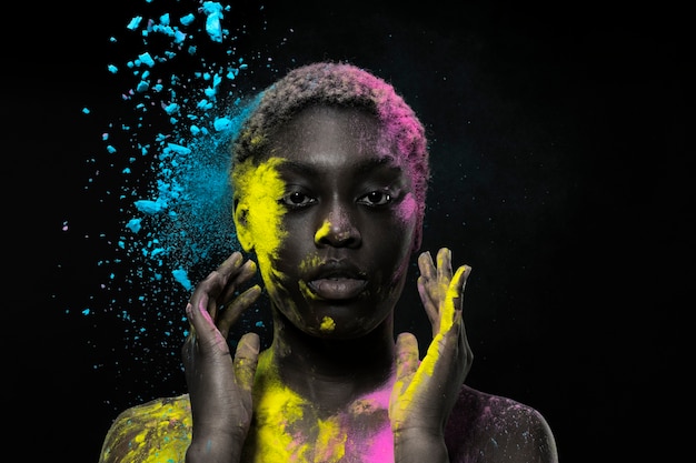 다채로운 가루와 함께 포즈를 취하는 흑인 여성
