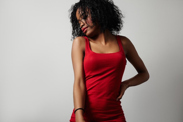 Черная женщина в красном платье показывает красивое тело
