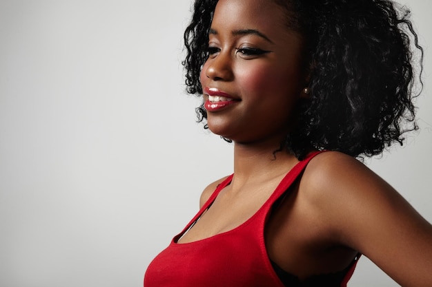 Black woman in red dress with bright red lips and curly hair
