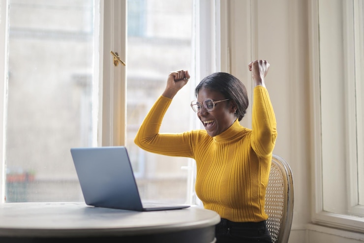 Free Photo black woman rejoices in front of a computer