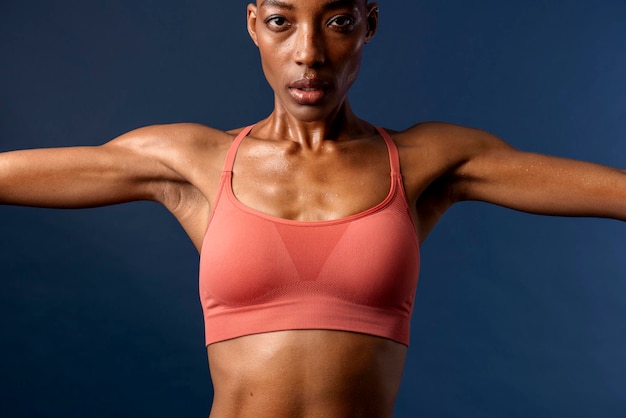 Black woman in sportswear stretching out her arms