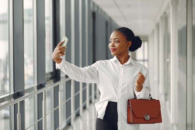 Black woman standing in the office with a laptop