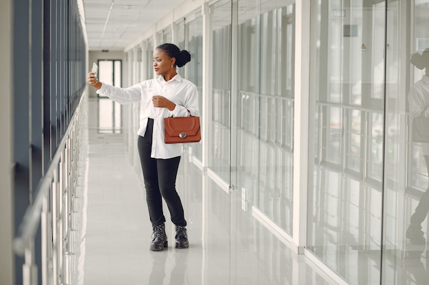 Black woman standing in the office with a laptop