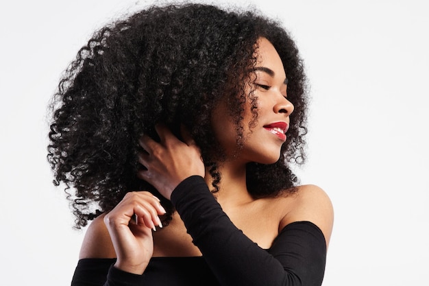 Black woman touches her curly hair