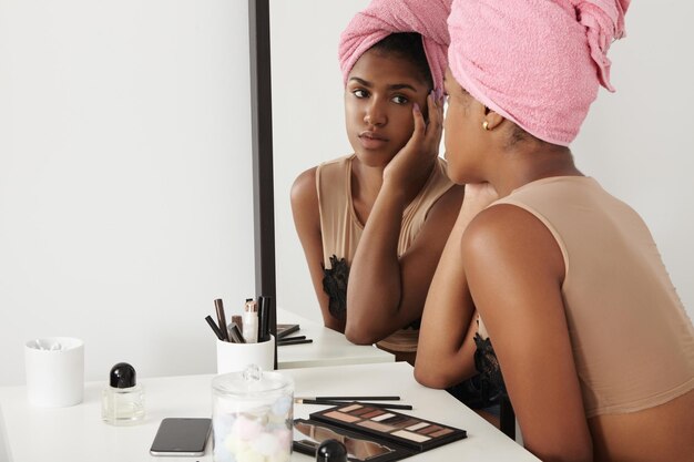 Black woman watching at herself in mirror