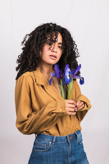 Foto gratuita donna di colore con fiori blu in camicia